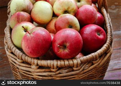 Bright tasty ripe apples in a basket, close-up