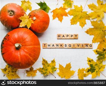 Bright Thanksgiving greeting card with ripe pumpkins, autumn leaves and and inscription. Preparing for the holidays. Congratulations for loved ones, relatives, friends and colleagues. Bright Thanksgiving greeting card with ripe pumpkins