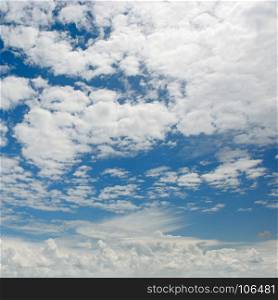 Bright white clouds on background of dark blue sky.