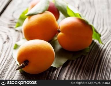 Bright yellow ripe juicy apricots on a wooden background. Bright yellow ripe juicy apricots