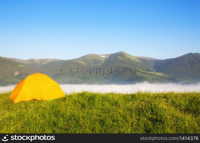 bright yellow tourist tent in the mountains nature