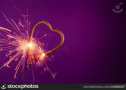 Brightly burning sparkler heart shaped. Love wedding valentines day party bengal fire.