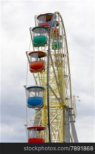 Brightly colored Ferris wheel against a background of clouds