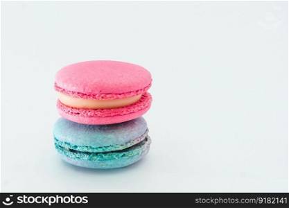 Brightly colored stacked up French macarons on white. Tasty colourful macaroons. Blue and pink macaroons isolated on white background. French pastry made from egg whites. Concept of food, desserts