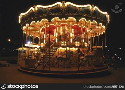 Brightly illuminated traditional carousel in Paris France at night