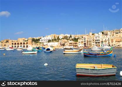 Brightly painted Maltese boats on blue water in summer, Malta.