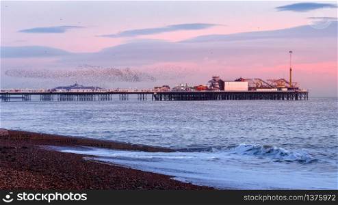 BRIGHTON, EAST SUSSEX/UK - JANUARY 26 : Starlings over the Pier in Brighton East Sussex on January 26, 2018. Unidentified people