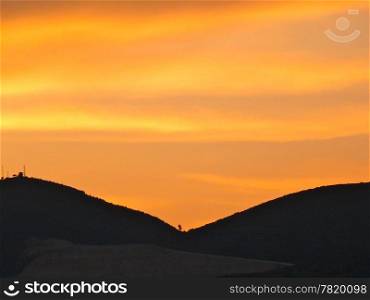 brightorange sunset with mountains in shadow