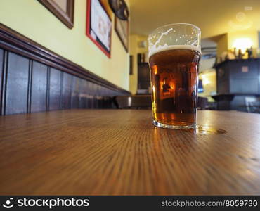 British ale beer pint. A pint of British ale beer on a pub table, wide angle view with copy space