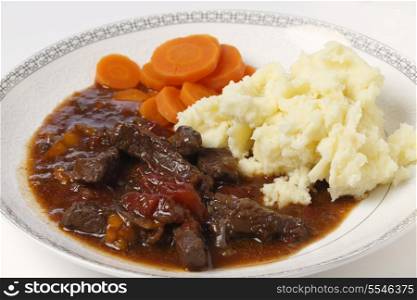 British beef and tomato casserole, served with mashed potatoes and boiled carrots.