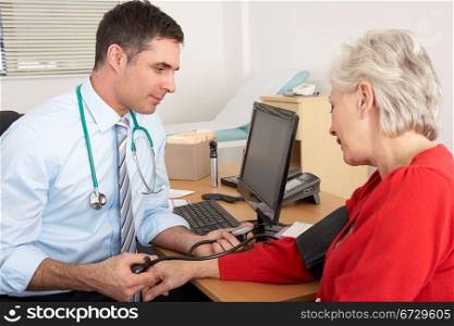 British doctor taking senior woman&acute;s blood pressure