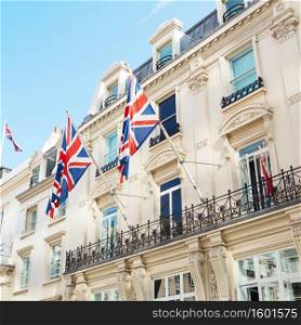 British flags flying on the balcony of a historic building in central London