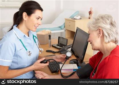 British nurse taking senior woman&acute;s blood pressure