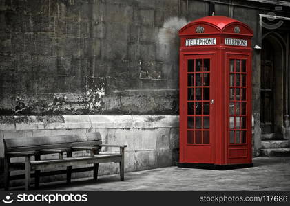 British Phone Booth in London, United Kingdom. British Phone Booth With Weathered Wooden Bench