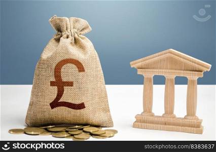 British pound sterling money bag and bank / government building. Budgeting, national financial system. Support businesses in crisis. Lending loans, deposits. Monetary policy. Resource allocation.