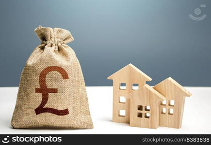 British pound sterling money bag and residential buildings. Mortgage loan. Property tax. Investment in real estate. Purchase of housing. City municipal budget. Costs of service and maintaining.