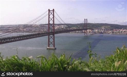 Brncke von Lissabon; rote Brncke aus Stahl nber dem Flu? Tejo; im Hintergrund die Stadt.