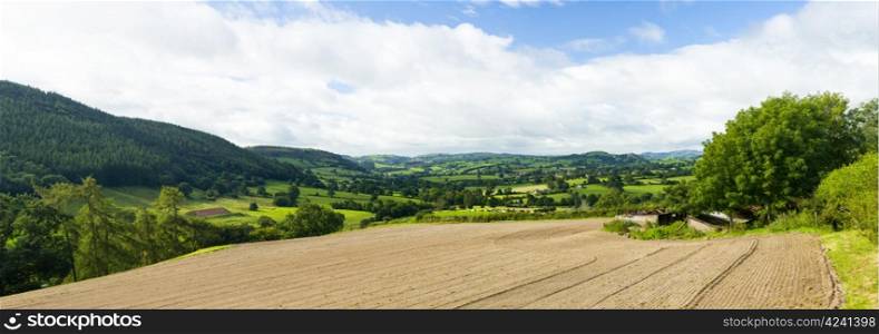 Broad panorama of the countryside in North Wales with ploughed field in foreground