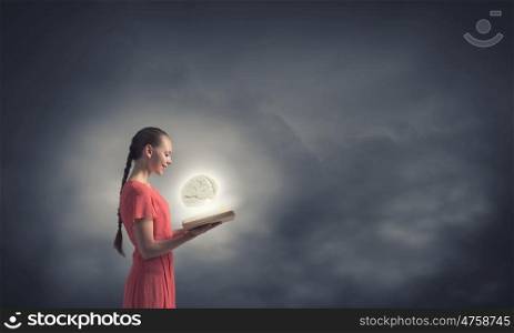 Broaden your mind. Young woman in red dress with book in hands
