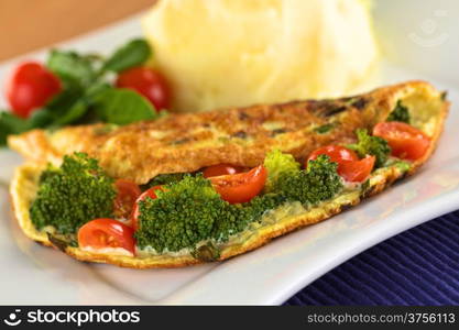 Broccoli and tomato omelette with mashed potato and watercress salad (Selective Focus, Focus on the broccoli floret in the front). Broccoli and Tomato Omelette