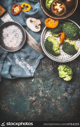 Broccoli , champignons mushroom and other vegetarian cooking ingredients with kitchen knife on dark rustic background, top view, border. Healthy food, Diet nutrition or Detox concept