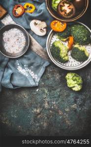 Broccoli , champignons mushroom and other vegetarian cooking ingredients with kitchen knife on dark rustic background, top view, border. Healthy food, Diet nutrition or Detox concept