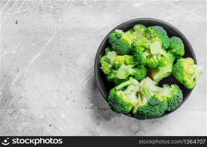 Broccoli in a bowl. On rustic background.. Broccoli in a bowl.