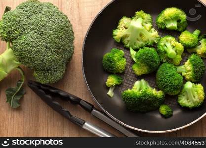 Broccoli in pan on wood kitchen table