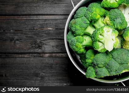 Broccoli in pot . On a wooden background.. Broccoli in pot .