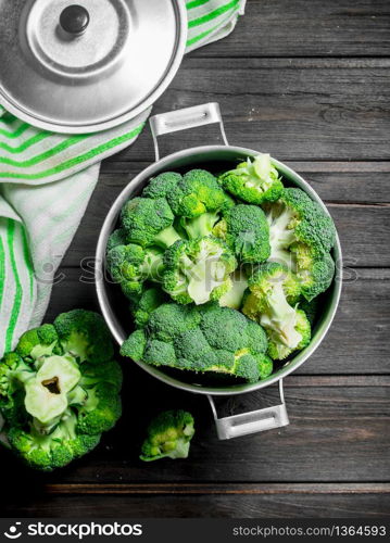 Broccoli in pot . On a wooden background.. Broccoli in pot .