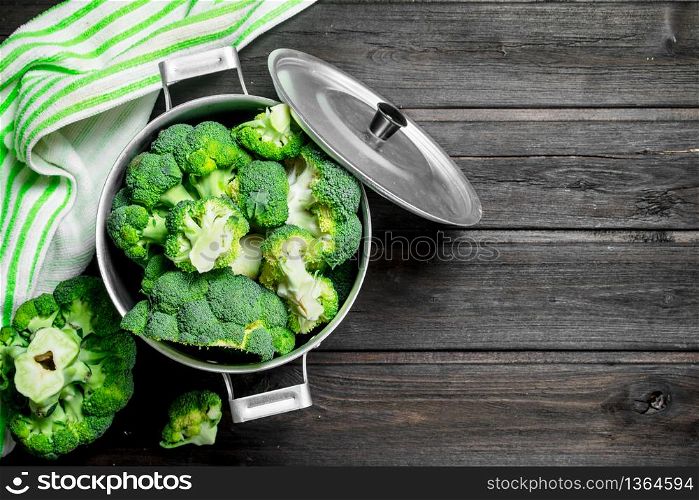 Broccoli in pot . On a wooden background.. Broccoli in pot .