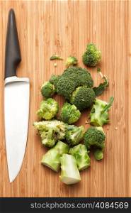 Broccoli on wooden board with kitchen knife