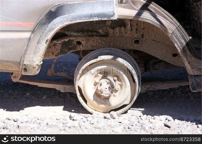 Brocken wheel of the dusty car in desert