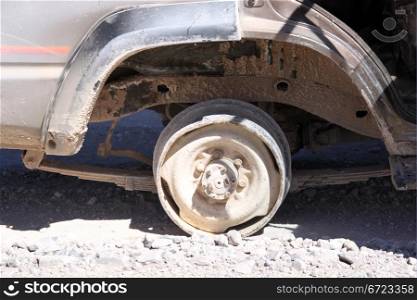 Brocken wheel of the dusty car in desert