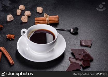 Broken black chocolate pieces with star anise and cinnamon on black background. Broken black chocolate pieces with star anise and cinnamon