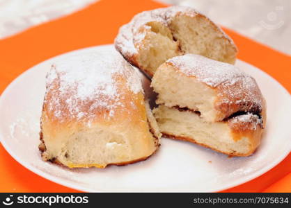 broken bun sprinkled with sugar on a white plate