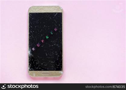 Broken cracks mobile phone and text Repair on pink background Concept Copy Space Top view. Broken cracks mobile phone and text Repair