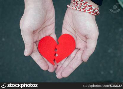 Broken heart in the hands - divorce concept.. Divorce concept - Broken heart in the male hands.