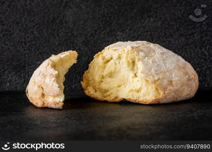 Broken loaf of bread on black background