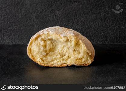 Broken loaf of bread on black background