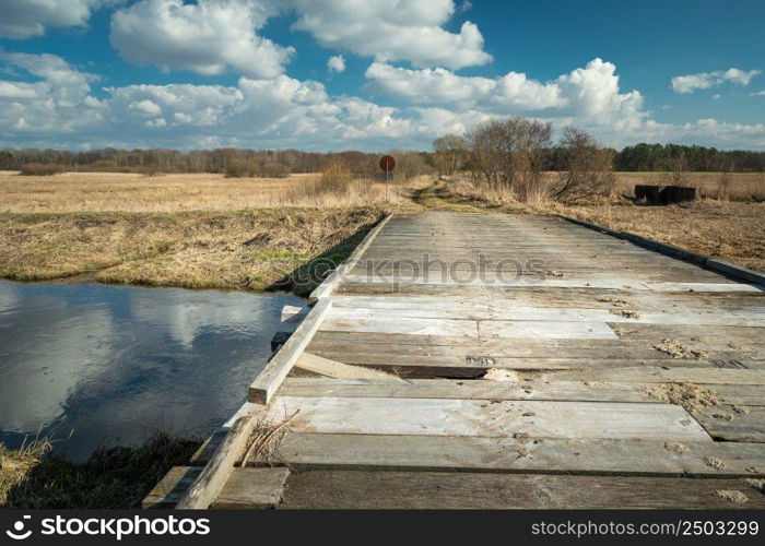 Broken plank in a wooden bridge on the river, sunny day, Czulczyce, Poland