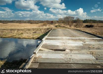 Broken plank in a wooden bridge on the river, sunny day, Czulczyce, Poland