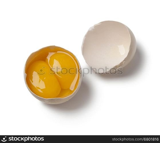 Broken raw double yolk egg in the shell on white background