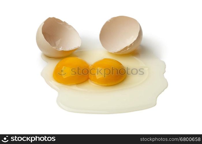 Broken raw double yolk egg on white background