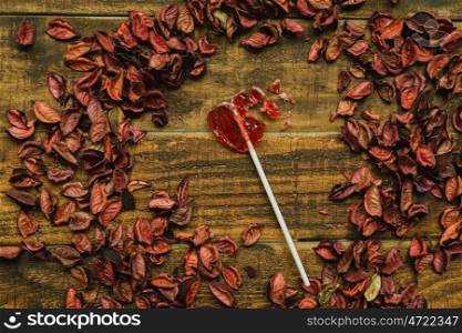 Broken red lollipo with heart shape on a wooden background
