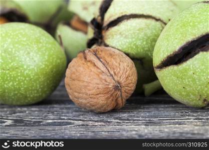broken ripe walnuts in early autumn or late summer, lie on a wooden floor after receiving the harvest.. broken ripe walnuts