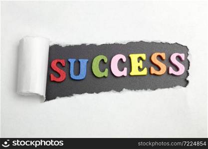 Broken sheet of paper behind the word success.. the word success in black-and-white background.