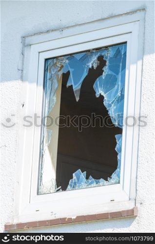 Broken window in a building. The concept of vandalism