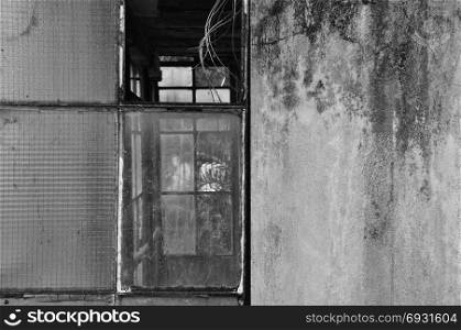 Broken windows and moldy wall background. Black and white.