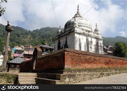 Bronze idol and white temple in Gorkha, Nepal